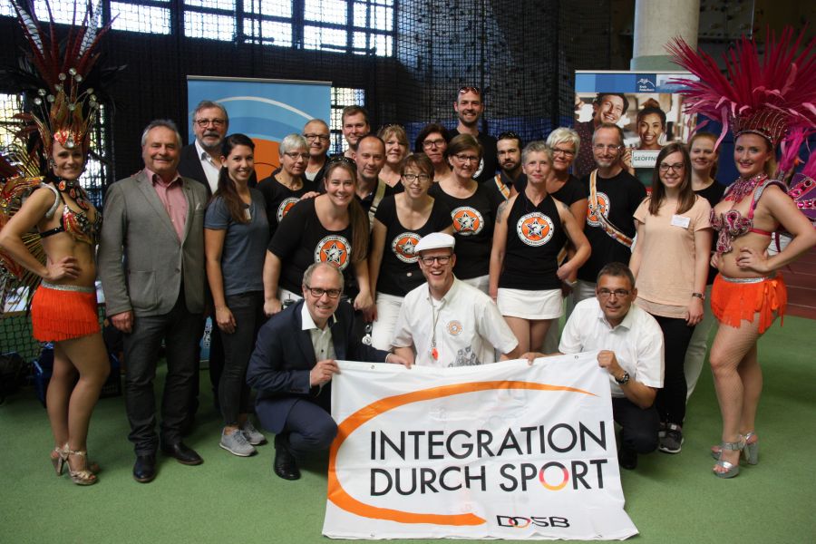 „Tanz aller Kulturen“ im Ahorn-Sportpark. Samba-Trommelgruppe „Querschläger Paderborn“ mit dem Organisatorenteam: Landrat Manfred Müller (1. Reihe, links), Diethelm Krause (Präsident KreisSportbund, 2. von links), Bernhard Lünz (Geschäftsführer des Kommunalen integrationszentrums, 3. Von links), Uwe Stork (Vizepräsident KreisSportBund, 1. Reihe, rechts), Julia Meier (KreisSportBund, 4. von links), Katrin Neumann (3. von rechts). (Foto: Bildungs- und Integrationszentrum, Kreis Paderborn, Johanna Leifeld)
